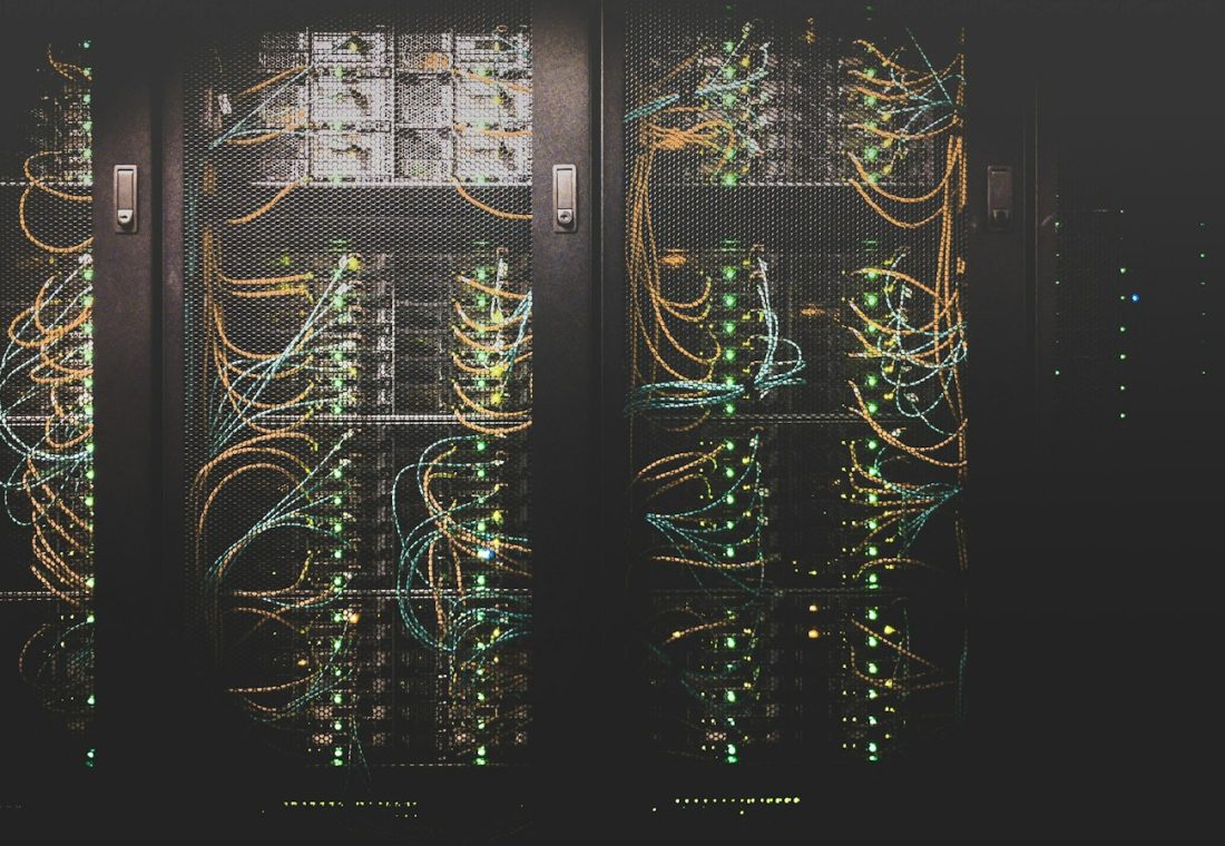 Ilustrasi ruang pusat data dengan server untuk menggambarkan infrastruktur komputasi AI