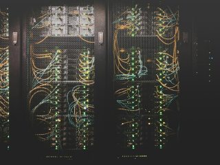 Ilustrasi ruang pusat data dengan server untuk menggambarkan infrastruktur komputasi AI